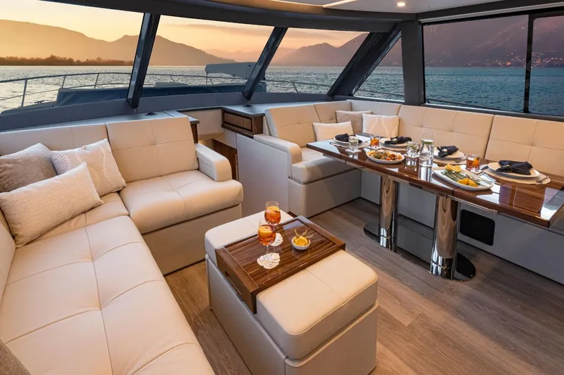 Slide: The Image of Luxurious interior of 2026 Riviera 64 Sports Motor Yacht with elegant dining setup and scenic view. - 12