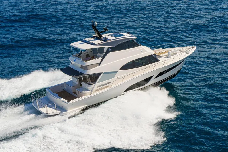 Slide: The Image of 2026 Riviera 64 Sports Motor Yacht Series II cruising on open sea. - 2