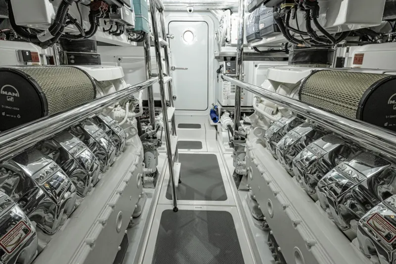 Slide: The Image of Engine room of 2026 Riviera 64 Sports Motor Yacht Series II, featuring dual MAN engines. - 24