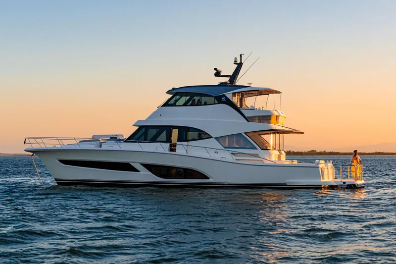Slide: The Image of 2026 Riviera 64 Sports Motor Yacht Series II at sunset on the water. - 4
