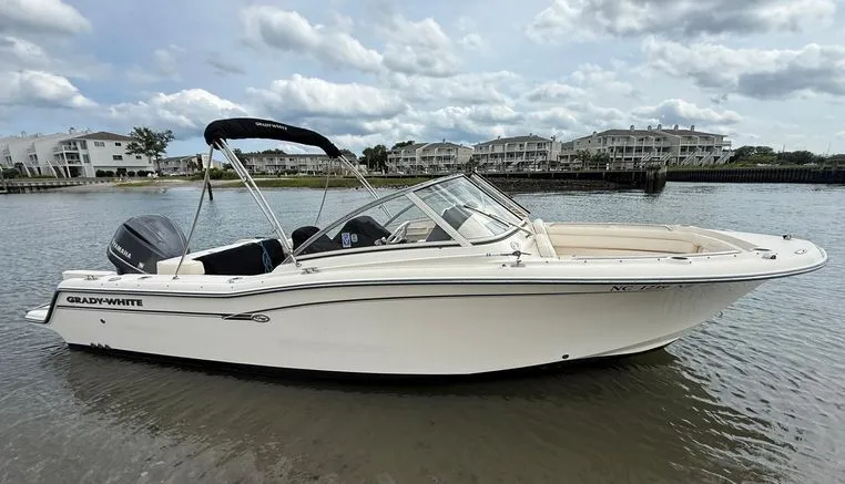 Slide: The Image of 2017 Grady-White Freedom 235 boat on calm water with buildings in the background. - 3