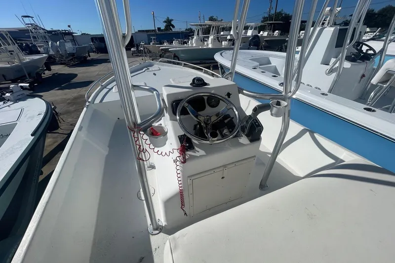 Slide: The Image of 2012 Slayer VS 19 boat console with steering wheel and controls, docked among other boats. - 11