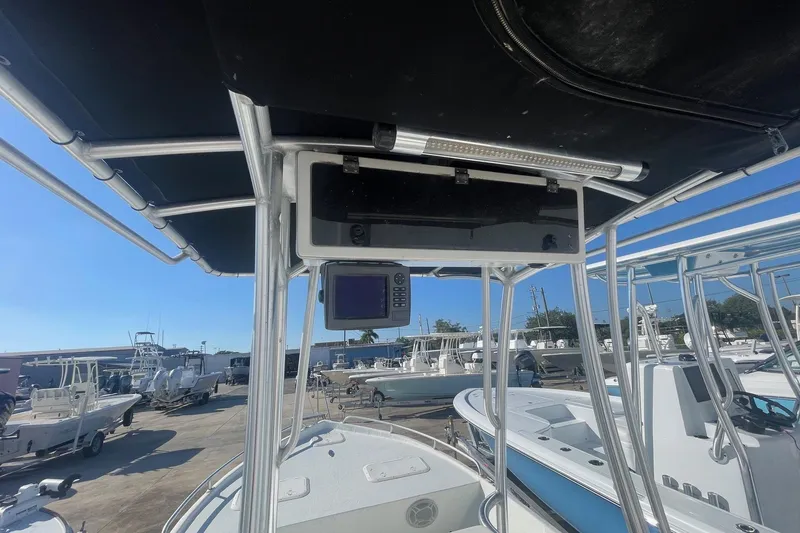 Slide: The Image of 2012 Slayer VS 19 boat with T-top and electronic equipment, docked among other boats. - 12