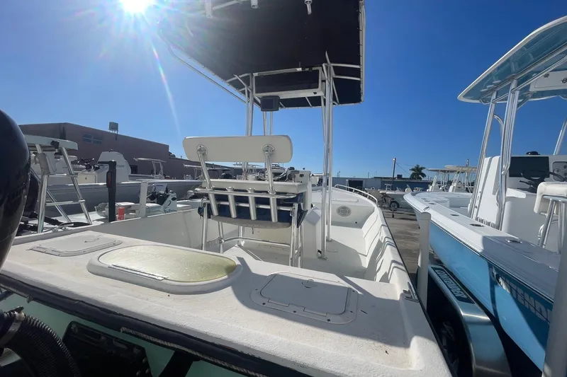 Slide: The Image of 2012 Slayer VS 19 boat with T-top, docked under clear blue sky. - 8