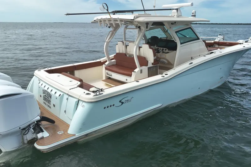 Slide: The Image of 2018 Scout 380 LXF boat on water, featuring sleek design and spacious seating. - 1