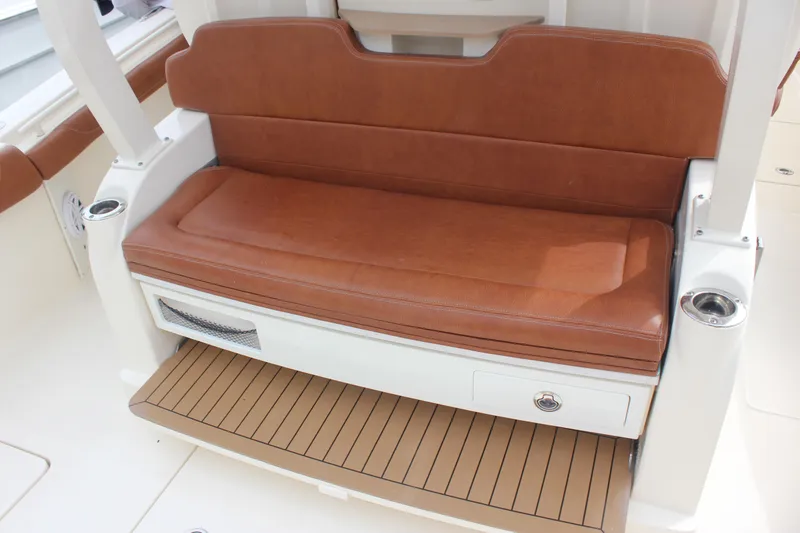 Slide: The Image of Luxurious brown leather seating on 2018 Scout 380 LXF boat, featuring storage and cup holders. - 11