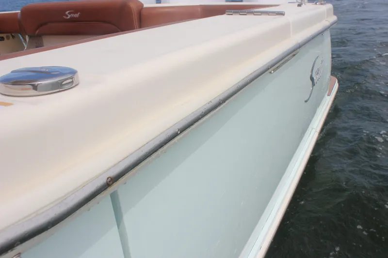 Slide: The Image of 2018 Scout 380 LXF boat side view on water, showcasing sleek design. - 12