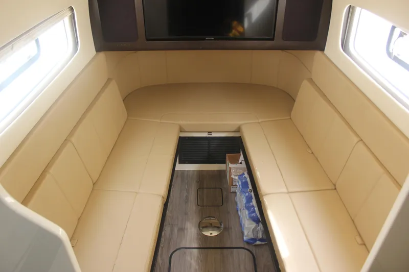Slide: The Image of Interior of 2018 Scout 380 LXF boat with beige seating and wood flooring. - 14