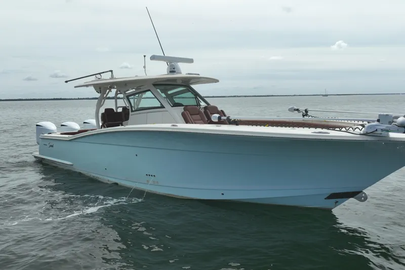 Slide: The Image of 2018 Scout 380 LXF boat on calm water, featuring sleek design and modern amenities. - 2