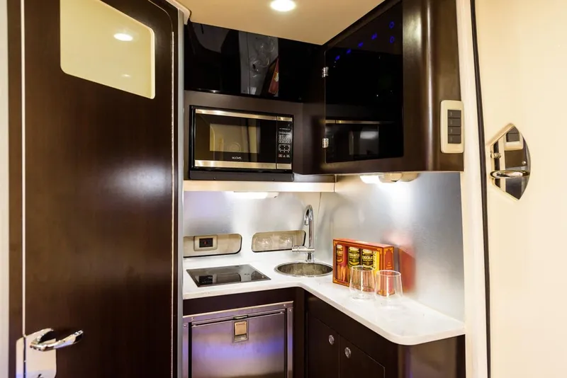 Slide: The Image of Manufacturer Provided Image: 2018 Scout 380 LXF boat kitchen with microwave, sink, and stovetop. - 23