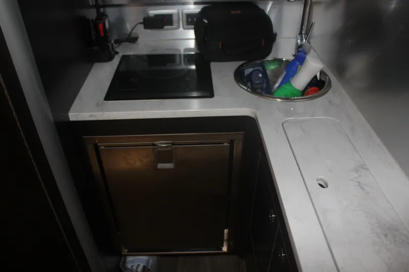 Slide: The Image of Compact kitchen area in a 2018 Scout 380 LXF boat with stove and sink. - 26