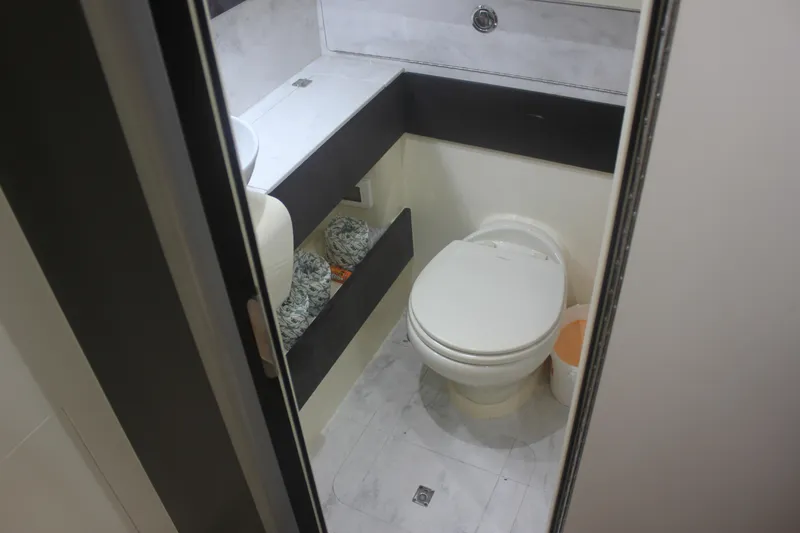 Slide: The Image of 2018 Scout 380 LXF boat bathroom interior with toilet and storage shelves. - 28