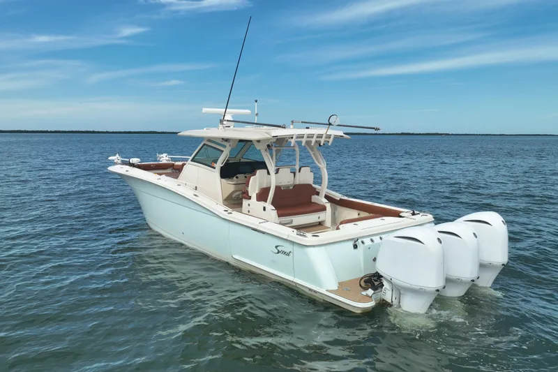 Slide: The Image of 2018 Scout 380 LXF boat on calm water, featuring triple outboard engines. - 3