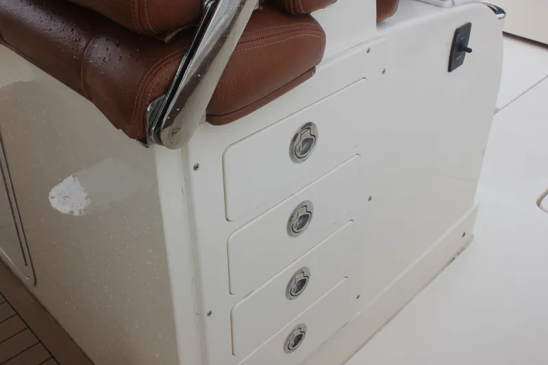 Slide: The Image of 2018 Scout 380 LXF boat interior with brown leather seating and storage drawers. - 40