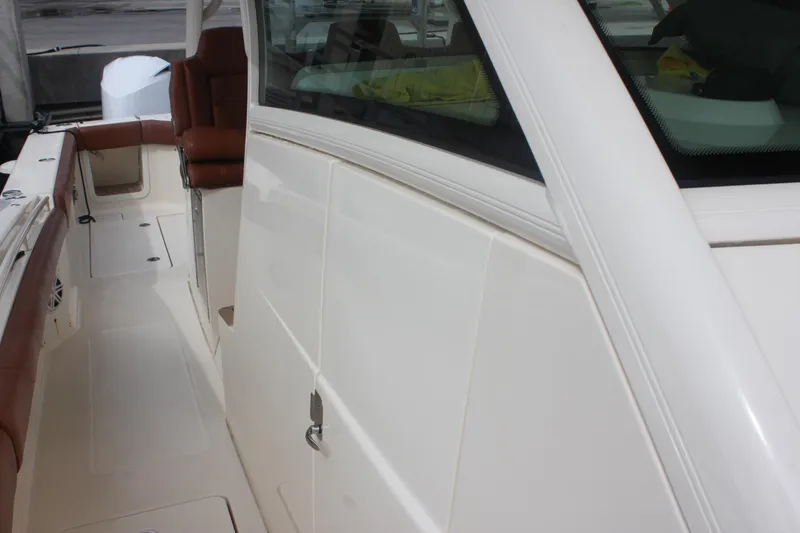 Slide: The Image of 2018 Scout 380 LXF boat interior with brown seating and sleek white design. - 44