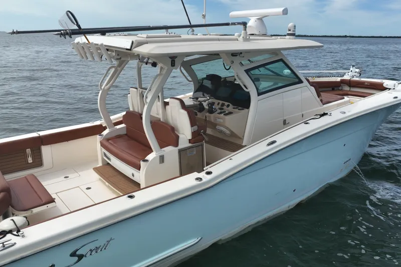 Slide: The Image of 2018 Scout 380 LXF boat on water, featuring sleek design and spacious seating. - 5