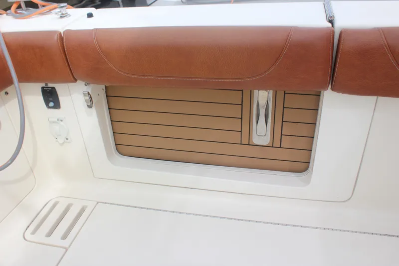 Slide: The Image of 2018 Scout 380 LXF boat interior with brown leather seating and storage compartment. - 51