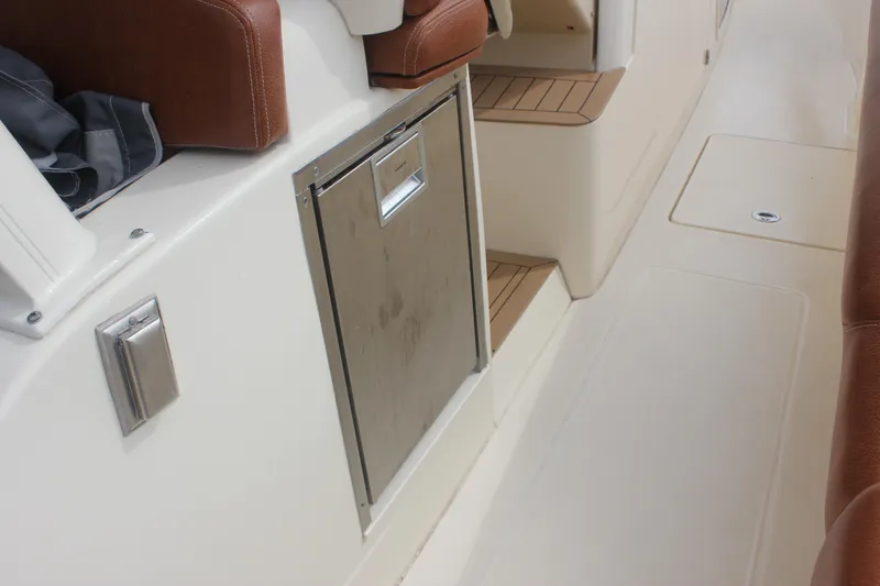 Slide: The Image of 2018 Scout 380 LXF boat interior with stainless steel storage and brown leather seating. - 52