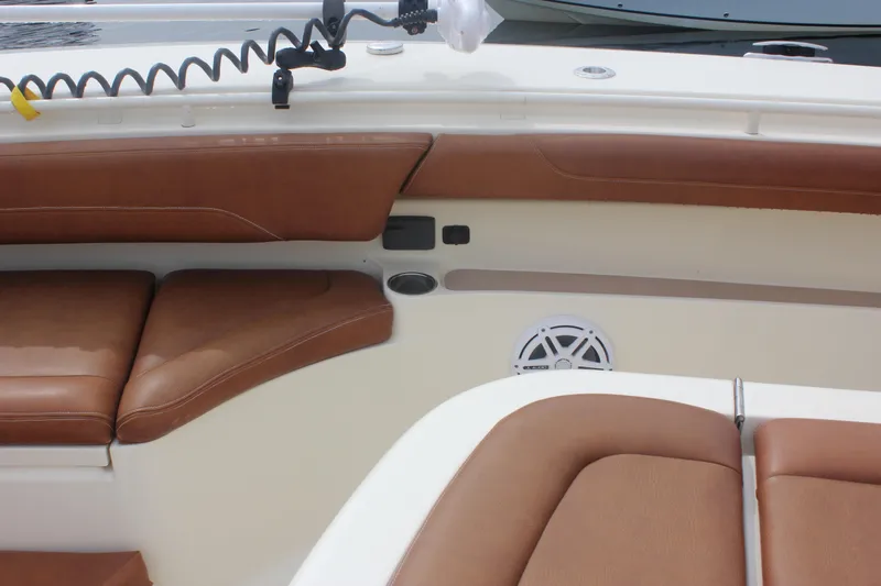 Slide: The Image of 2018 Scout 380 LXF boat interior with brown leather seating and speaker. - 60