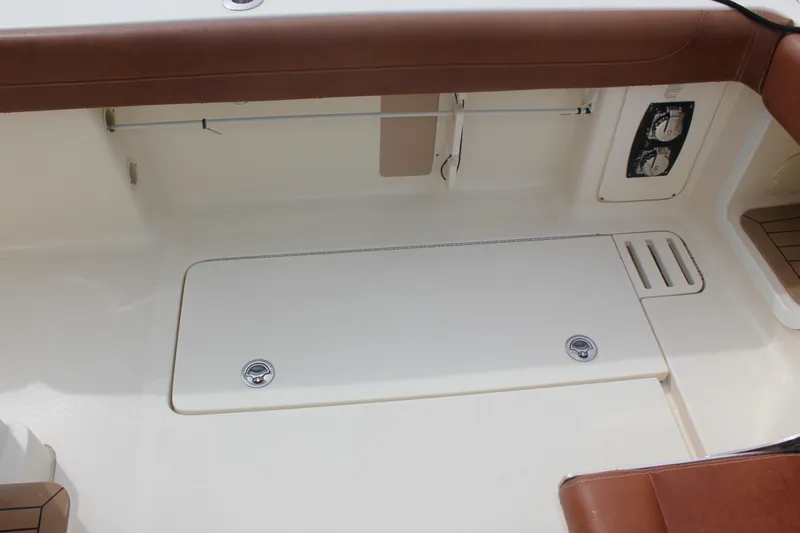 Slide: The Image of 2018 Scout 380 LXF boat interior with storage compartment and brown seating. - 63