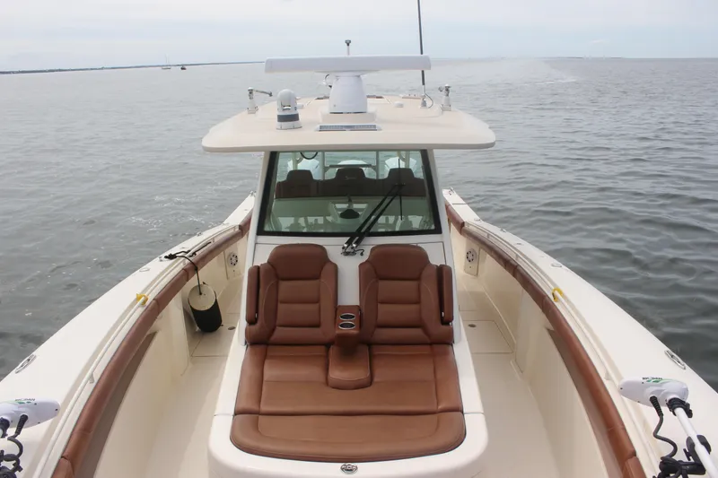 Slide: The Image of 2018 Scout 380 LXF boat with luxurious seating on calm waters. - 7