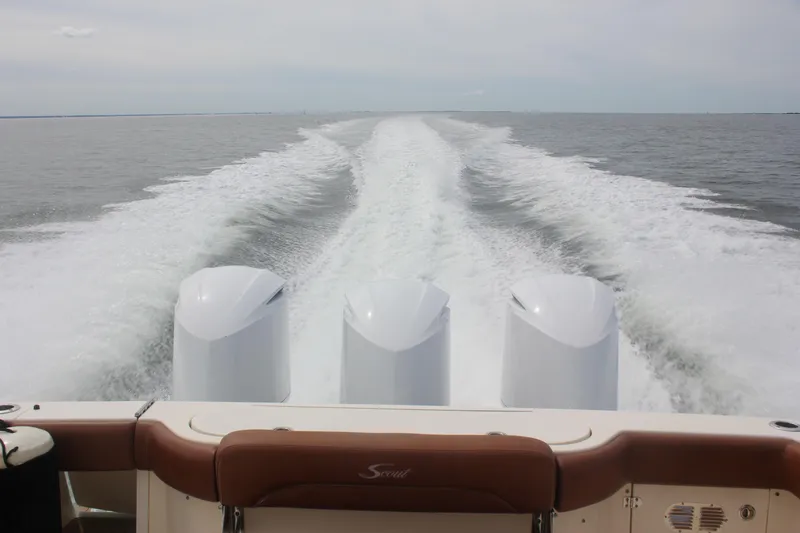 Slide: The Image of 2018 Scout 380 LXF boat cruising, leaving a wake in the water. - 73