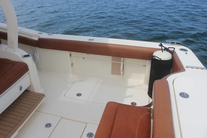 Slide: The Image of 2018 Scout 380 LXF boat interior with brown seating and ocean view. - 77