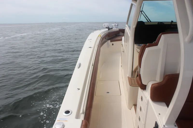 Slide: The Image of 2018 Scout 380 LXF boat cruising on open water, featuring luxurious seating and sleek design. - 78