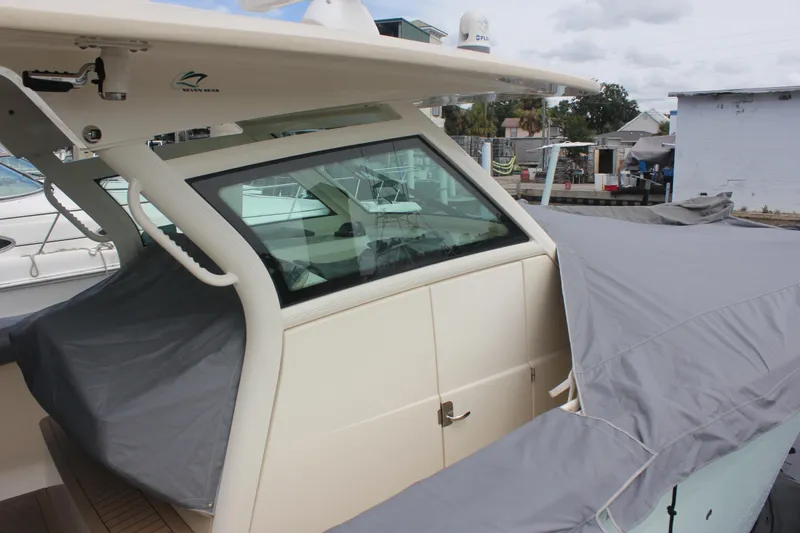 Slide: The Image of 2018 Scout 380 LXF boat with protective cover in a marina setting. - 82