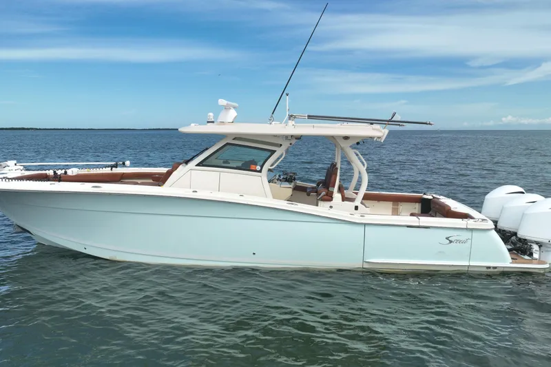 Slide: The Image of 2018 Scout 380 LXF boat on calm ocean waters under a clear blue sky. - 88