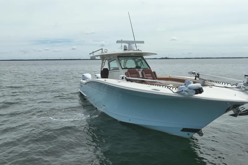 Slide: The Image of 2018 Scout 380 LXF boat on calm water, showcasing sleek design and luxury features. - 91