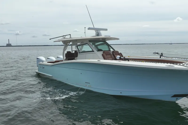 Slide: The Image of 2018 Scout 380 LXF boat on calm water, showcasing sleek design and luxury features. - 92