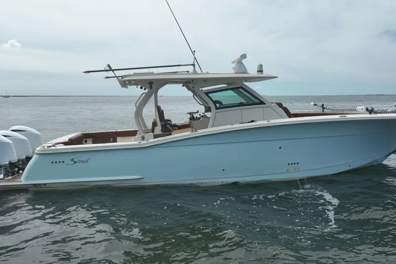 Slide: The Image of 2018 Scout 380 LXF boat on water, side view, light blue hull, triple engines. - 93
