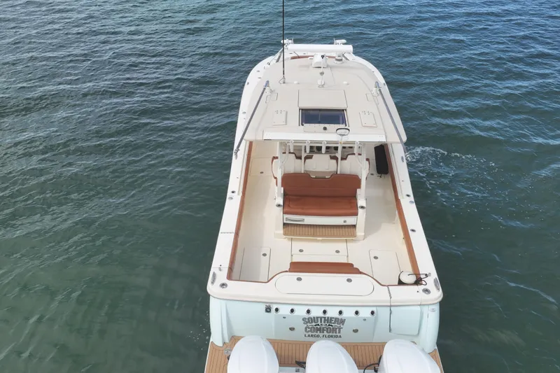 Slide: The Image of 2018 Scout 380 LXF boat on water, aerial view, featuring spacious deck and seating. - 96