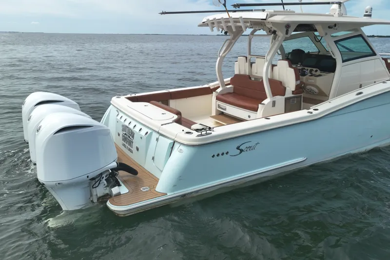 Slide: The Image of 2018 Scout 380 LXF boat with triple outboard engines on open water. - 97