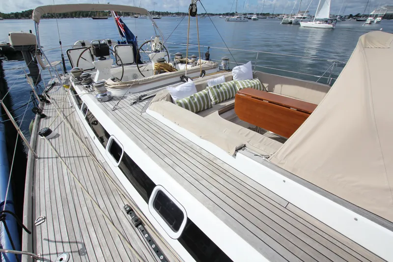 Slide: The Image of 2004 Nautor Swan 62 yacht deck with seating, docked in a serene marina. - 11