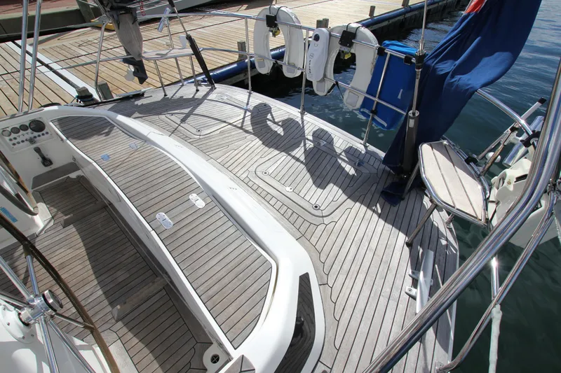 Slide: The Image of 2004 Nautor Swan 62 yacht deck with wooden finish and docked at marina. - 18