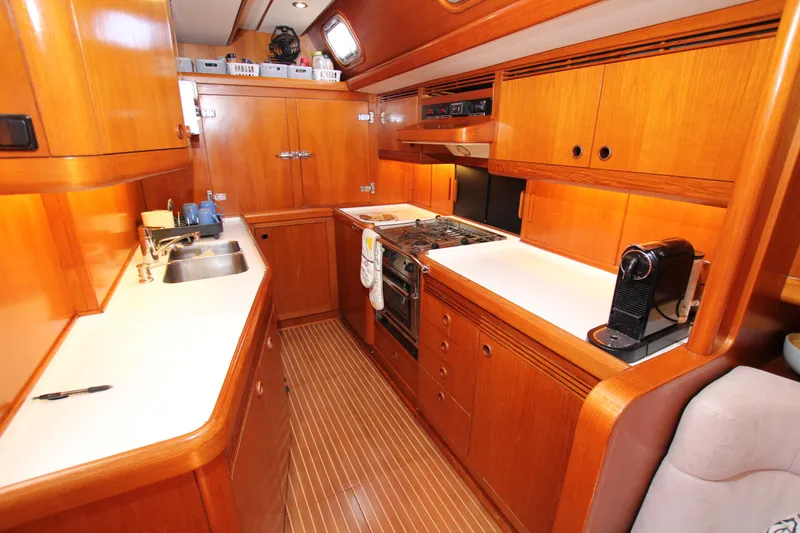 Slide: The Image of Luxurious wooden galley in 2004 Nautor Swan 62 yacht, featuring modern appliances and ample storage. - 38