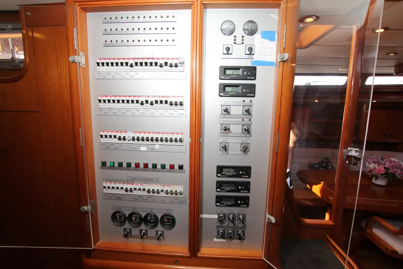 Slide: The Image of Electrical control panel inside 2004 Nautor Swan 62 yacht, featuring switches and gauges. - 43
