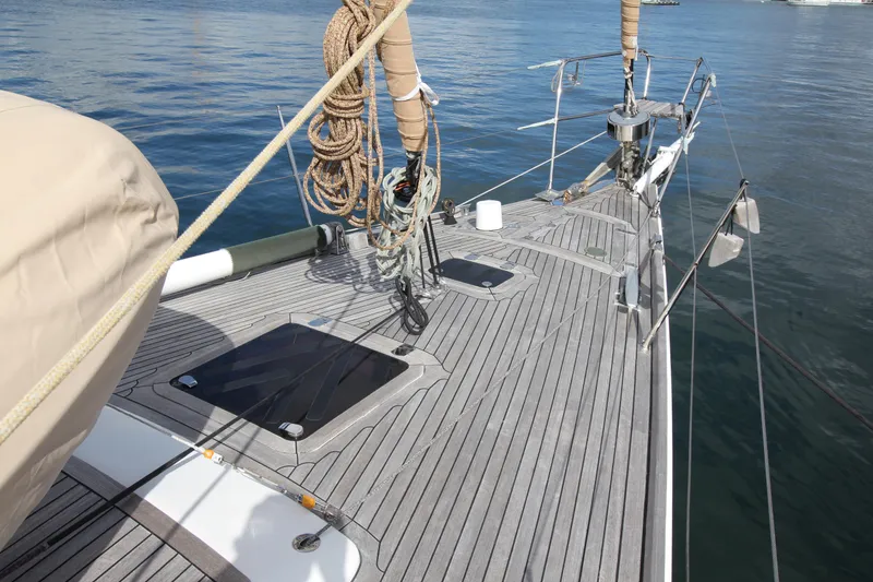 Slide: The Image of Deck of 2004 Nautor Swan 62 yacht with ropes and hatches, docked on calm water. - 5