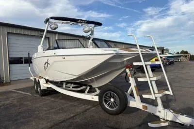 Slide: The Image of 2026 ATX Surf Boats 24 Type-S on trailer, parked outdoors near a building. - 2