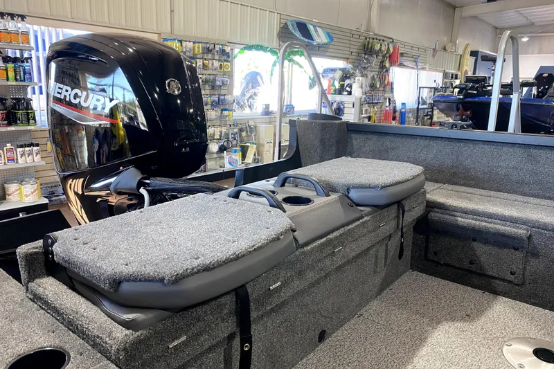 Slide: The Image of 2026 Alumacraft Voyageur 175 Sport boat interior with Mercury engine in showroom. - 11