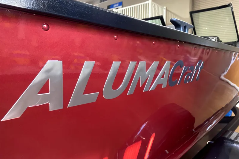 Slide: The Image of 2026 Alumacraft Voyageur 175 Sport boat with red exterior and logo. - 2