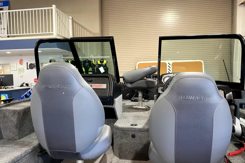 Slide: The Image of 2026 Alumacraft Voyageur 175 Sport boat interior with gray seats and dashboard. - 5