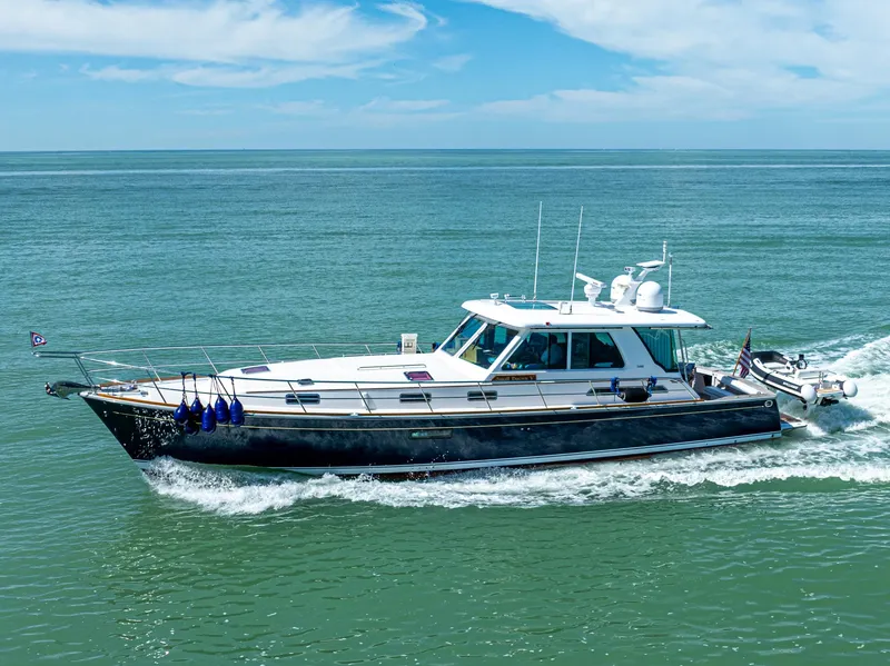 The Image of 2009 Sabre 52 Express yacht cruising on open water under a clear blue sky. - 0
