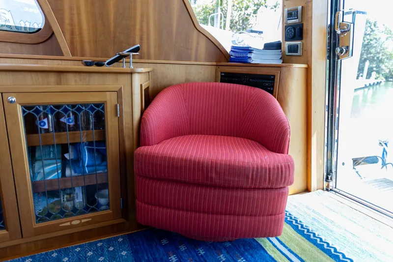 Slide: The Image of Red chair in 2009 Sabre 52 Express yacht interior, next to wooden cabinet and glass door. - 21