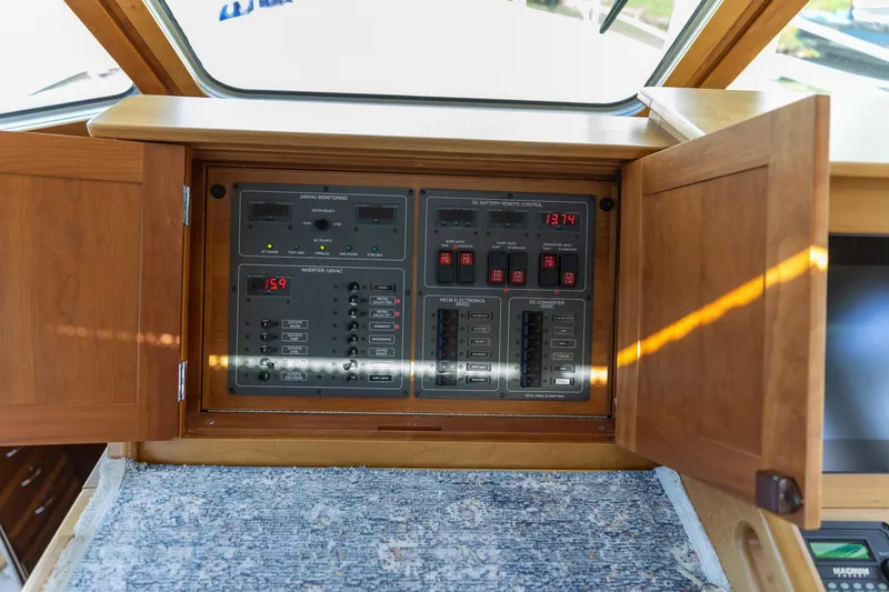 Slide: The Image of Electrical control panel on a 2009 Sabre 52 Express yacht, with wooden cabinet doors open. - 26