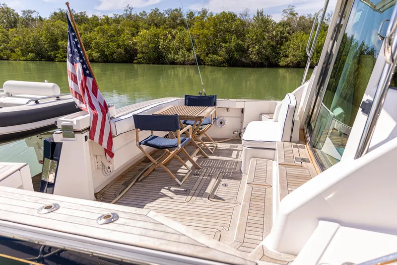 Slide: The Image of 2009 Sabre 52 Express yacht deck with seating, table, and American flag. - 3