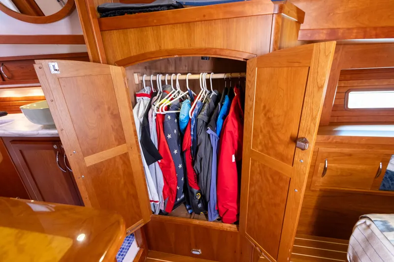 Slide: The Image of Wooden wardrobe with hanging clothes inside a 2009 Sabre 52 Express yacht interior. - 40