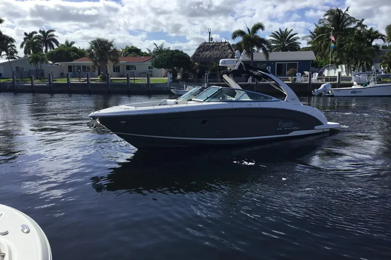 Slide: The Image of 2017 Regal 3200 Bowrider boat cruising on a sunny waterfront with palm trees. - 15